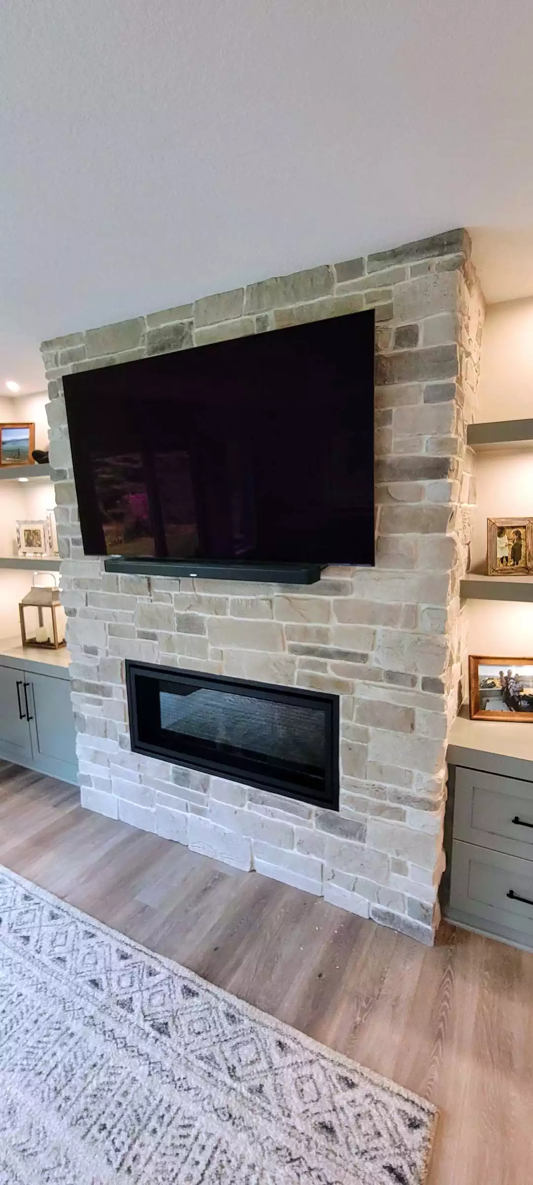 Stone wall gas fireplace with TV above