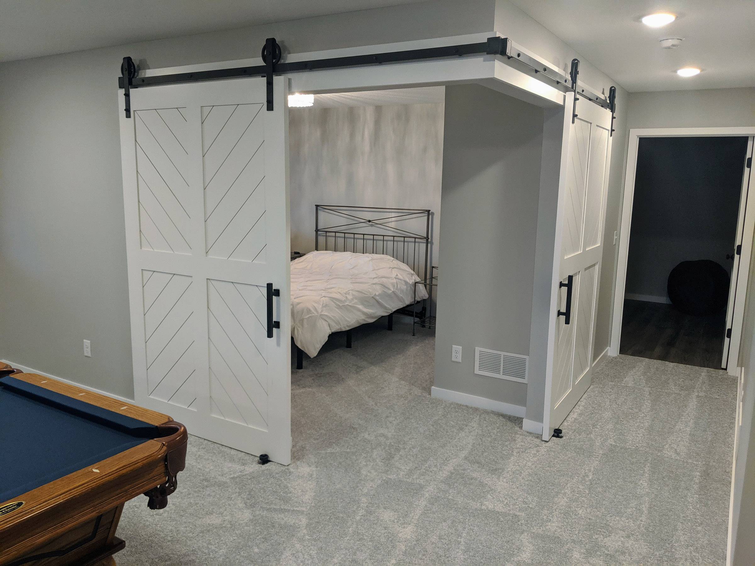 A set of Corner 5’ x 7’ Custom track doors, open the space to the guest bedroom