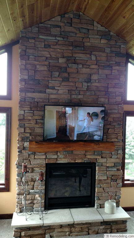  6’ x 14’ Stone fireplace w/ reclaimed timber mantle.